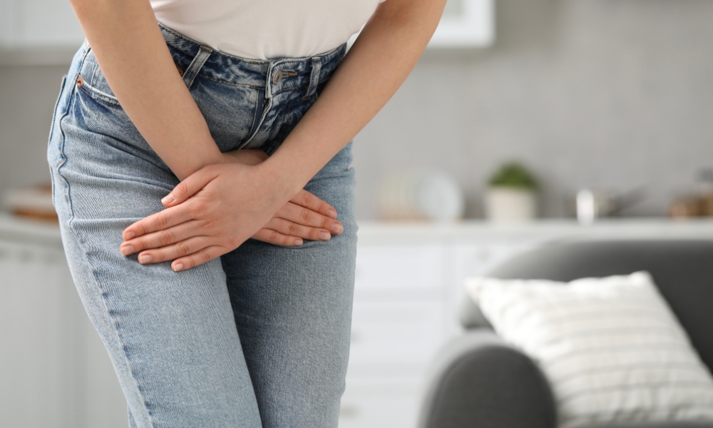 Woman experiencing urinary discomfort and urgency while holding her lower abdomen, illustrating common bladder health concerns