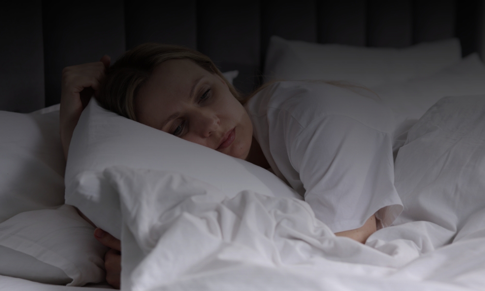 Woman lying awake in bed experiencing sleep difficulties related to menopause symptoms and hormonal changes